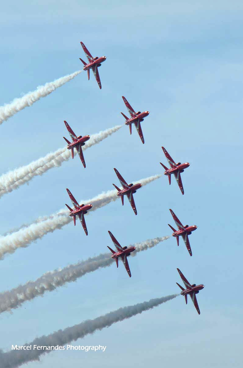 The Red Arrows captured mid-formation, precision and symmetry against a blue sky.
